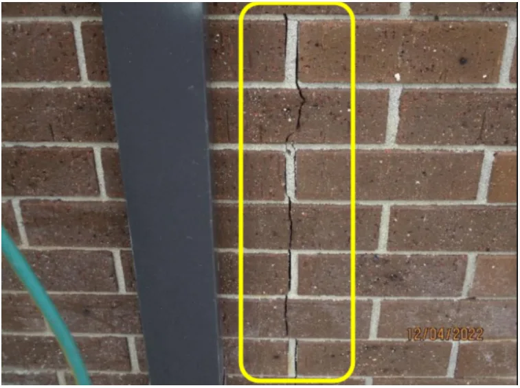 Example of a vertical orientated crack pattern in a masonry wall. The width and shape of a crack can help tell if a crack is structural.