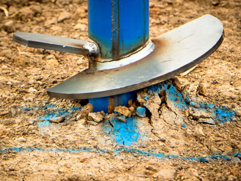 Head of a screw pile being “screwed” into soil