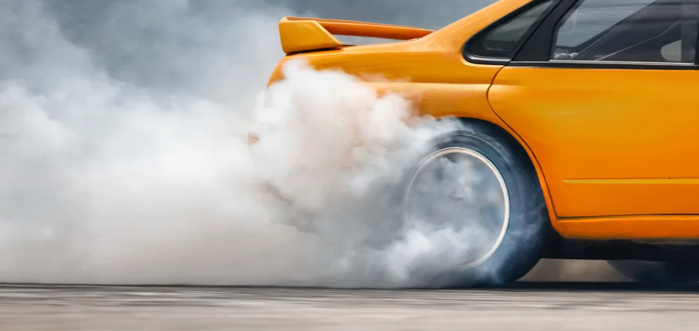 Drag cars perform burnouts before going down the quarter mile to build heat and therefore friction between the tyres and road surface