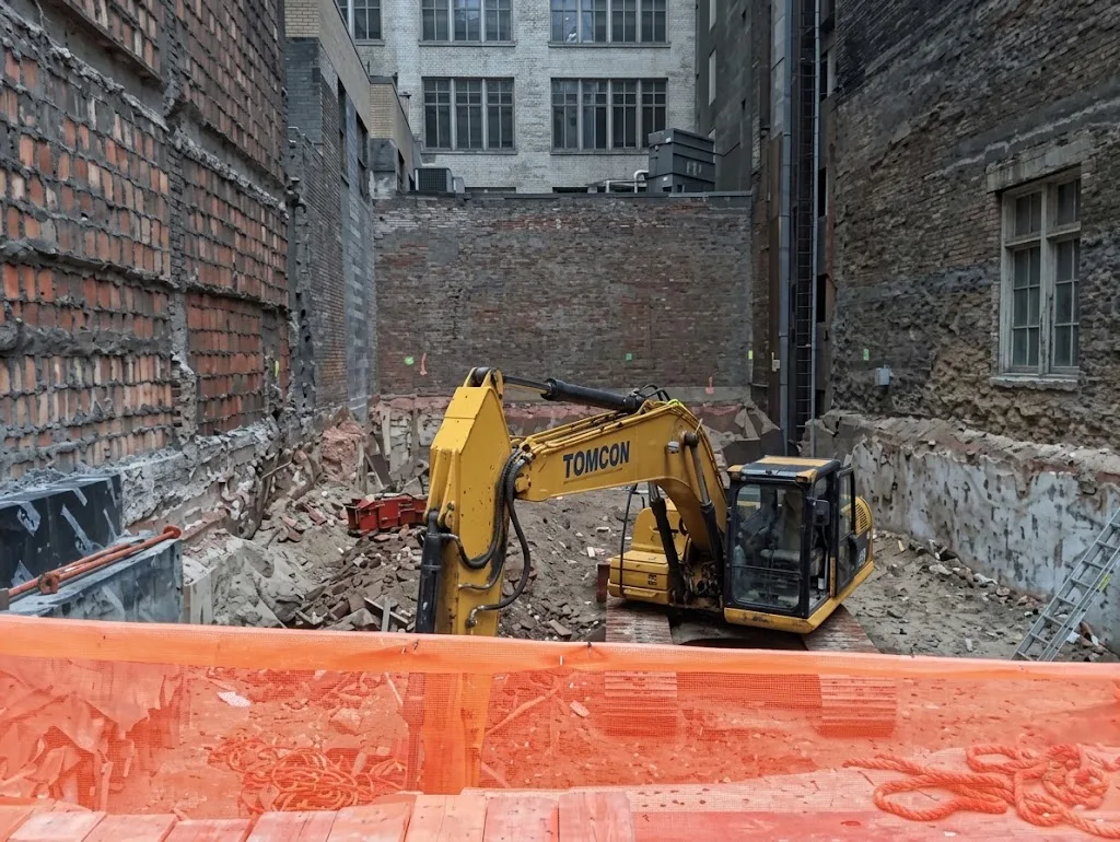 The excavator at the base of the Steinway Tower during construction of the foundations puts the slenderness of the tower into perspective.
