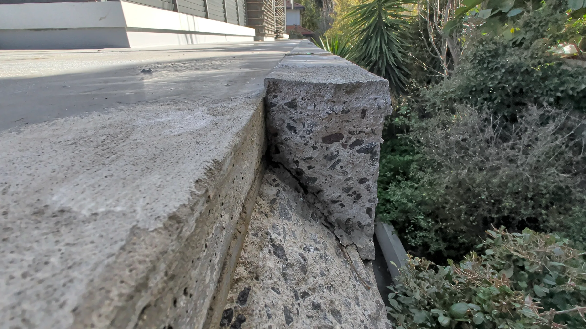 The cracked façade nib where concrete detached from the building.